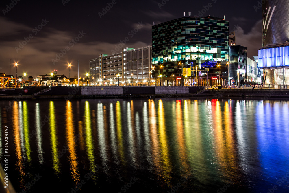 Reflections on a quick water at night from a highlighted industrial buildings in Salford, Manchester, United Kingdom