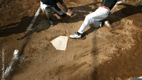 Overhead view of baseball player sliding into home plate