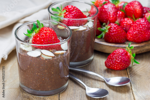 Chocolate chia seed pudding garnished with almond slices and strawberry