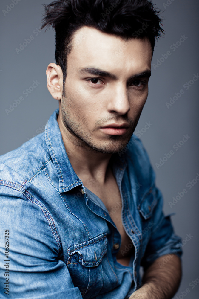 Fototapeta premium Portrait of handsome young man in casual denim clothes standing over white background
