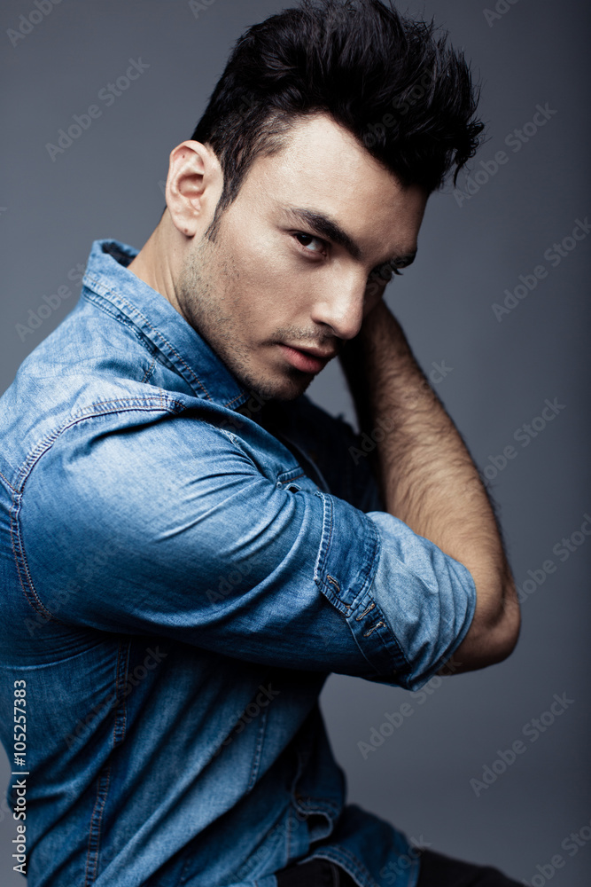 Portrait of handsome young man in casual denim clothes standing over white background