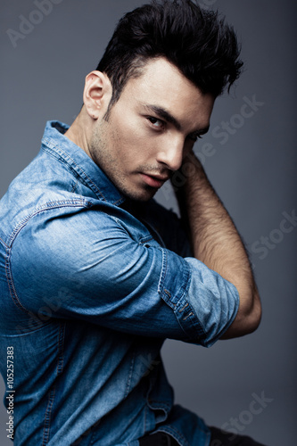 Portrait of handsome young man in casual denim clothes standing over white background
