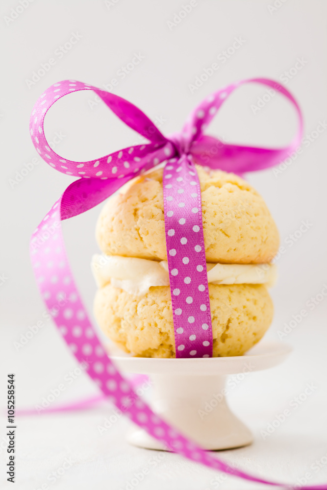 Vanilla whoopie pie with buttercream filling on cake stand Vanilla whoopie pie with buttercream filling on cake stand