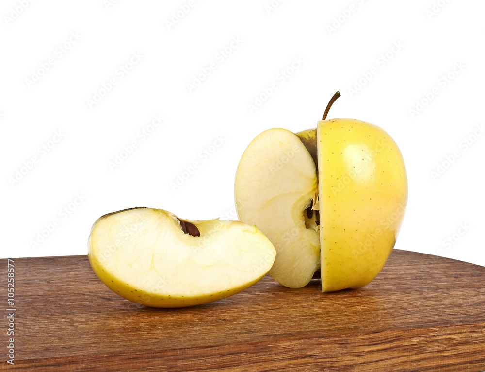 Yellow apple and slice on wooden cutting board on a white backgr Yellow apple and slice on wooden cutting board on a white backgr