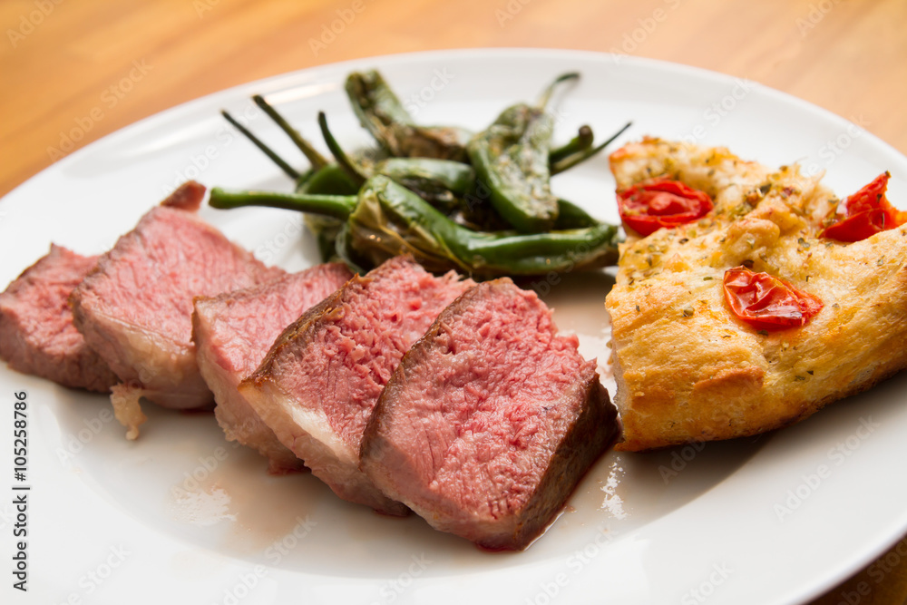 Steak with pimentos de padron and focaccia bread Steak with pimentos de padron and focaccia bread