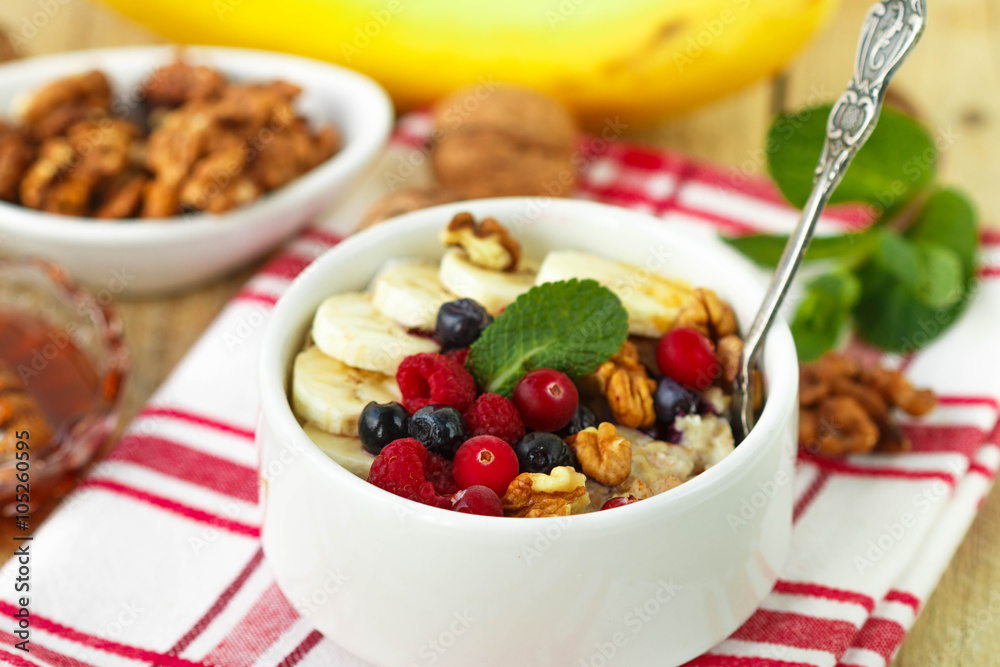 Healthy Breakfast. Oatmeal with fresh berries, bananas nuts and honey
Healthy Breakfast. Oatmeal with fresh berries, bananas nuts and honey