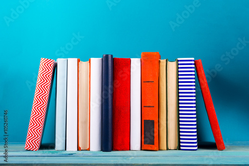 Stack of colorful books, grungy blue background, free copy space