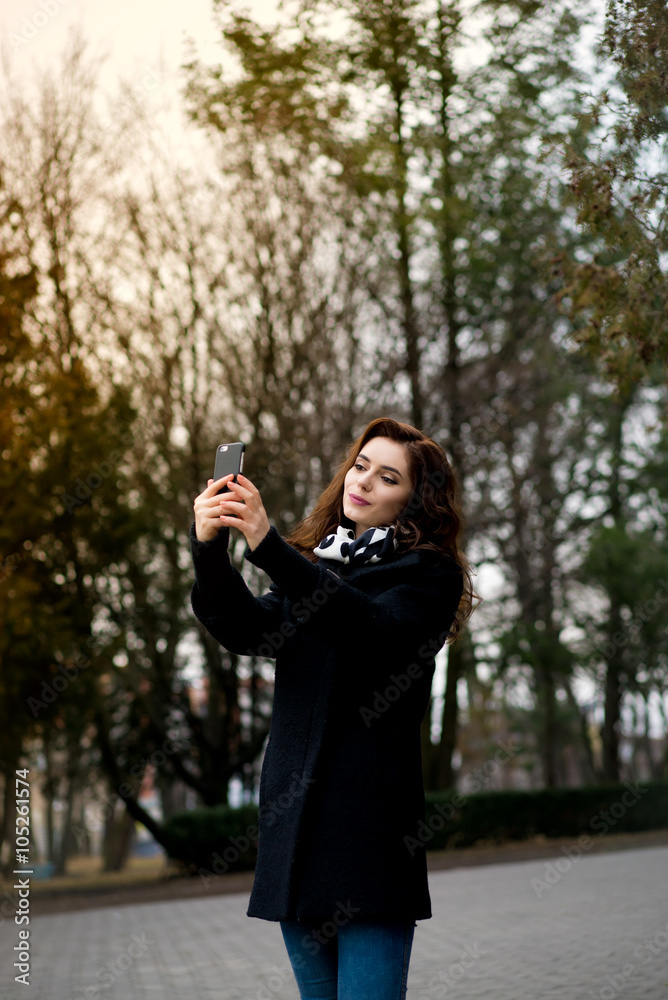 Beautiful young woman makes selfie in the park Beautiful young woman makes selfie in the park