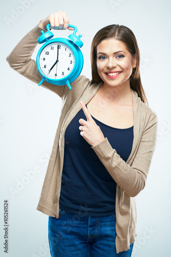 Smiling woman pointing on alarm clock.