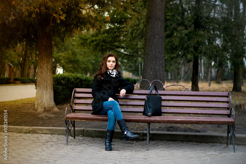 Beautiful girl sitting on a park bench