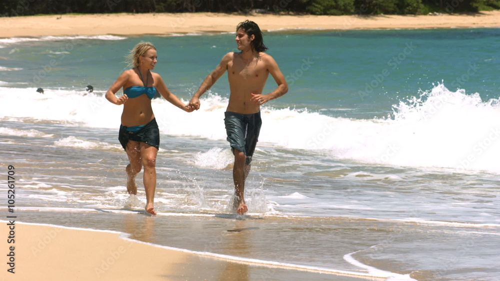 Young couple running on beach, slow motion Young couple running on beach, slow motion