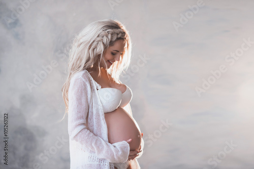 Portrait of a beautiful pregnant woman in white lingerie and long hair, lifestyle, waiting, belly