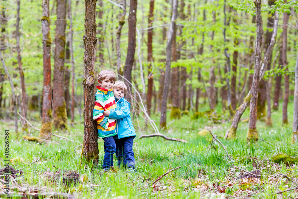 Two kid boys walking through forest on cold day Two kid boys walking through forest on cold day