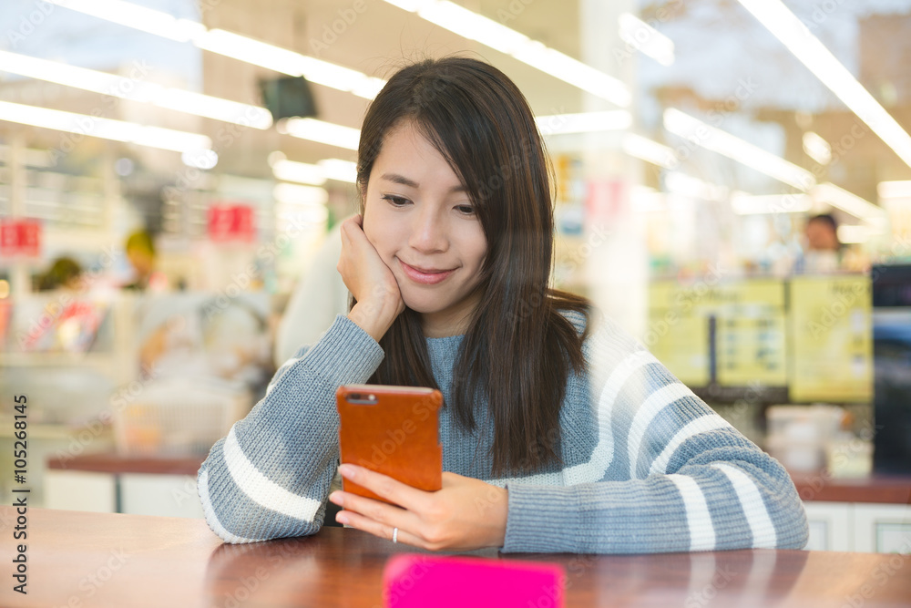 Woman look at cellphone in cafe Woman look at cellphone in cafe