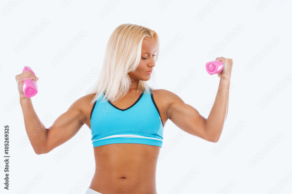 A woman holds a pair of dumbbells.