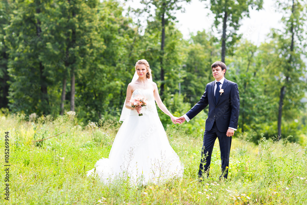 Bride and groom holding hands outdoors Bride and groom holding hands outdoors