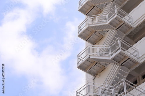 the fire escape which is a part of building with the sky and cloud
