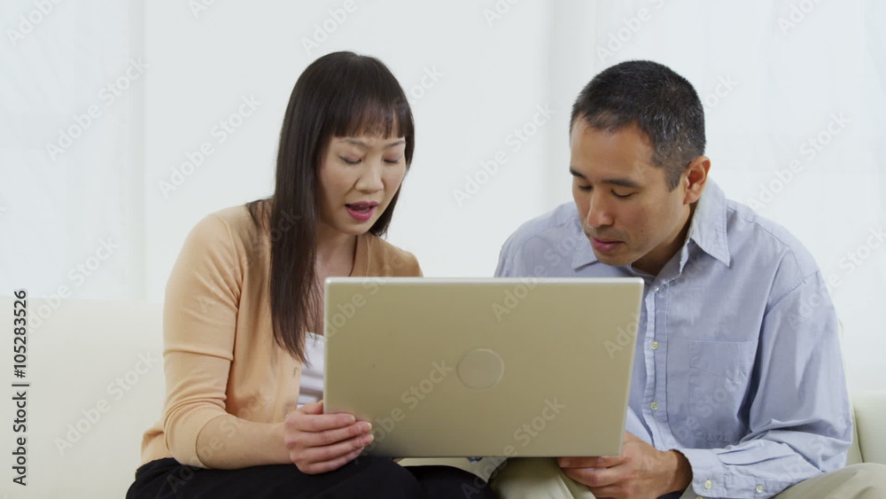 Asian couple using laptop computer together Asian couple using laptop computer together