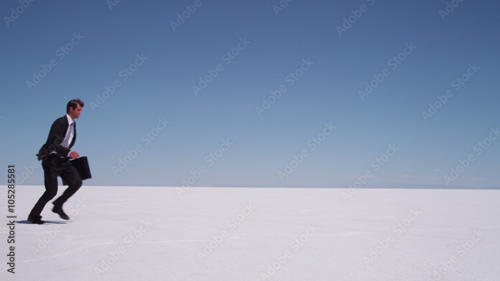 Businessman running and jumping at salt flat Businessman running and jumping at salt flat