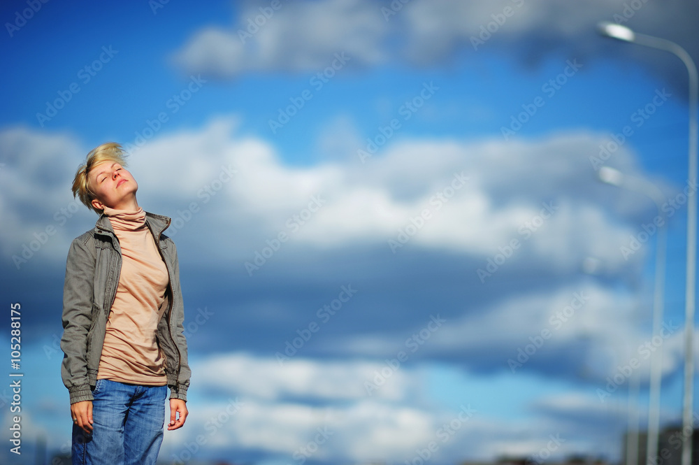 Portrait sad and stressed young woman suffering migraine headache, blue sky and clouds as background. And she relax. Portrait sad and stressed young woman suffering migraine headache, blue sky and clouds as background. And she relax.