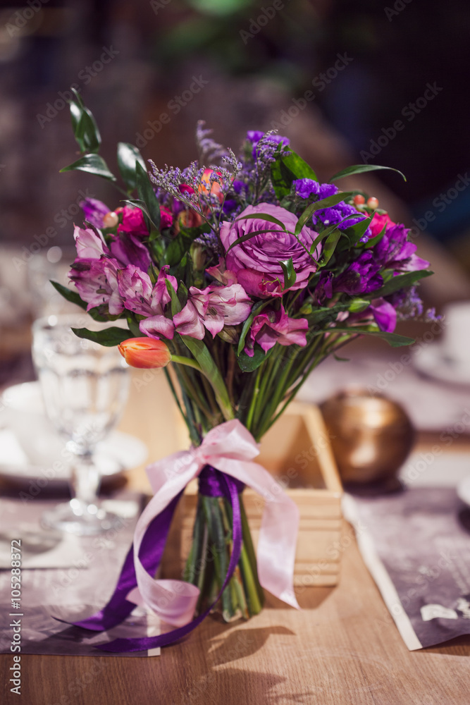 Flowers composition in restaurant,  roses and irises, combination shades of purple