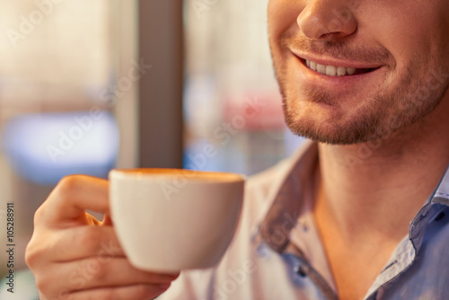 Positive man drinking coffee