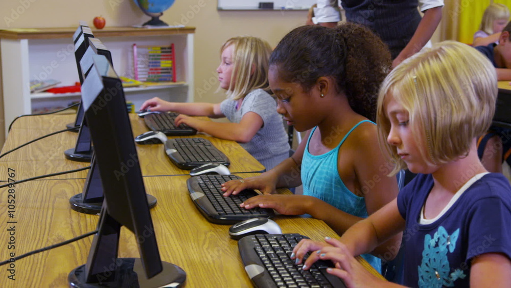 Elementary school teacher helps students with computers