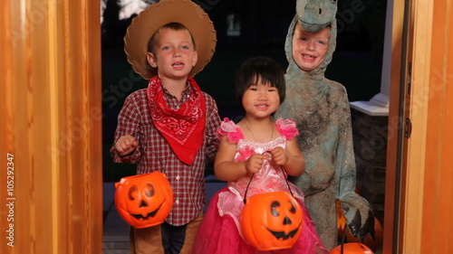 Three children in Halloween costumes trick or treating