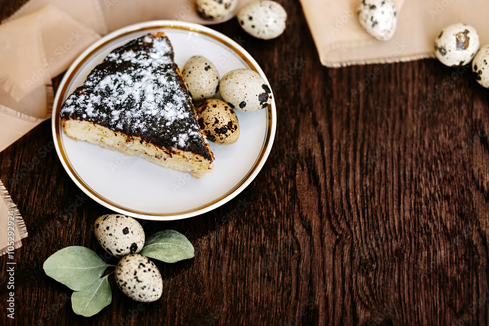 Piece of cake and quail eggs on a wooden background. Piece of cake and quail eggs on a wooden background.