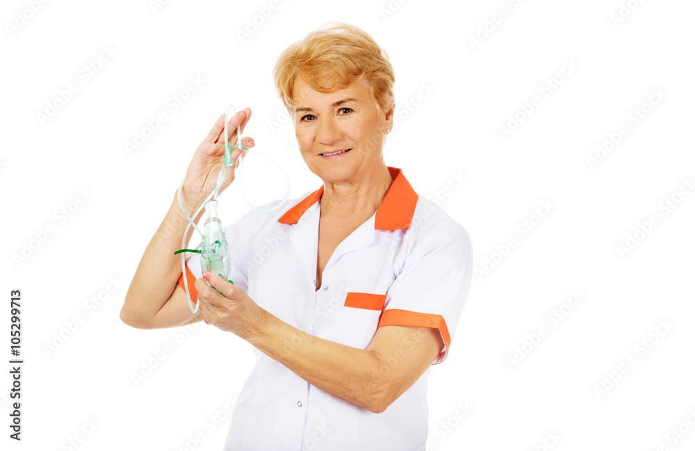 Smile elderly female doctor or nurse holds oxygen mask Smile elderly female doctor or nurse holds oxygen mask