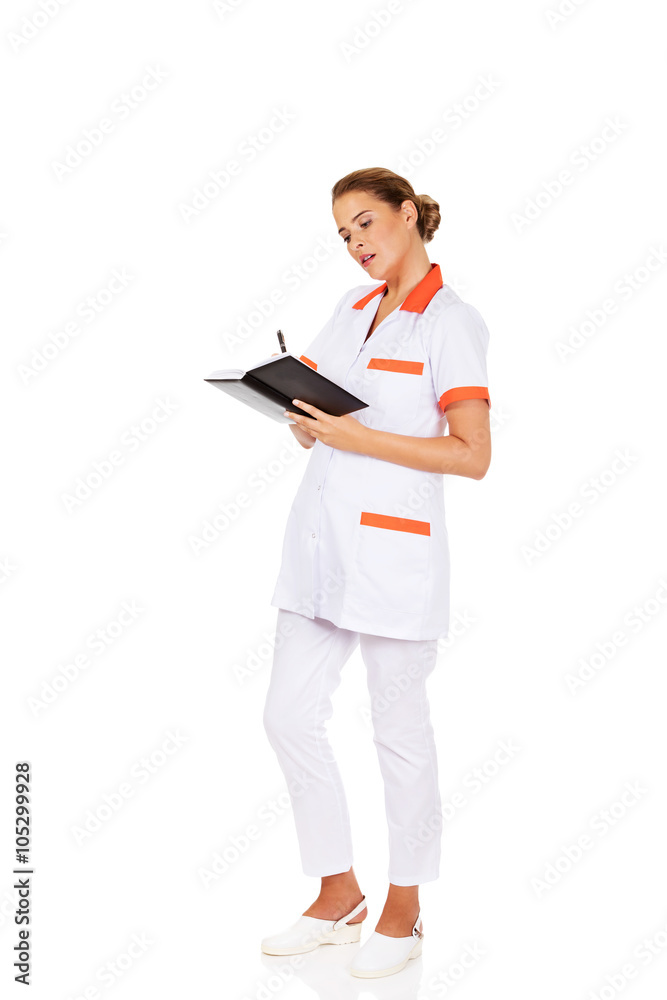 Young focus female doctor or nurse makes notes Young focus female doctor or nurse makes notes