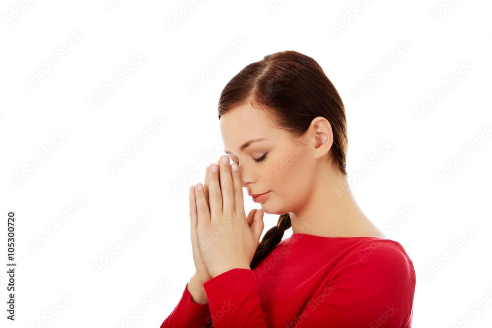 Young woman praying with her hands together Young woman praying with her hands together