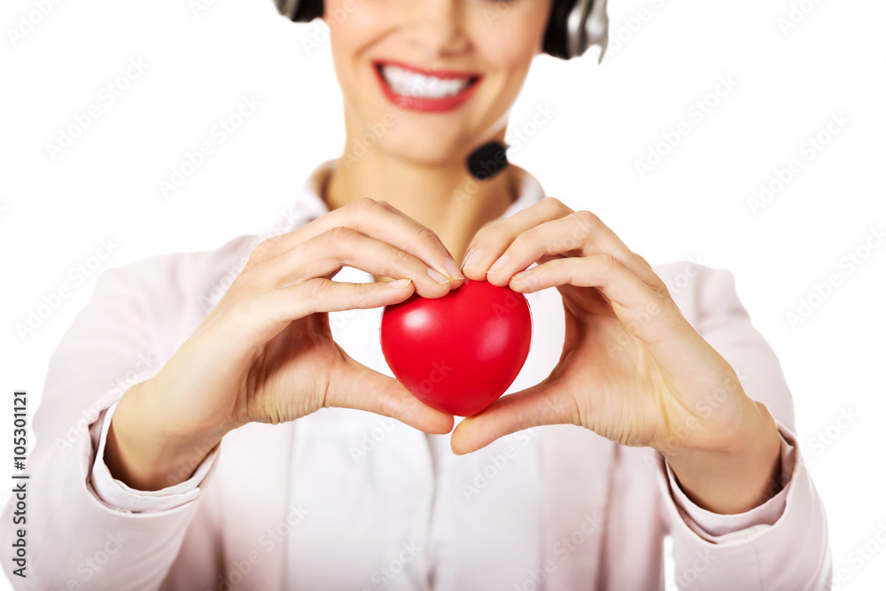 Happy call center woman holding heart toy Happy call center woman holding heart toy
