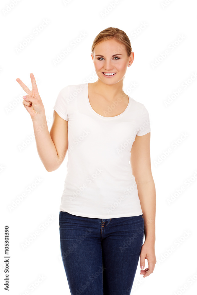 Smiling young woman showing the victory sign Smiling young woman showing the victory sign