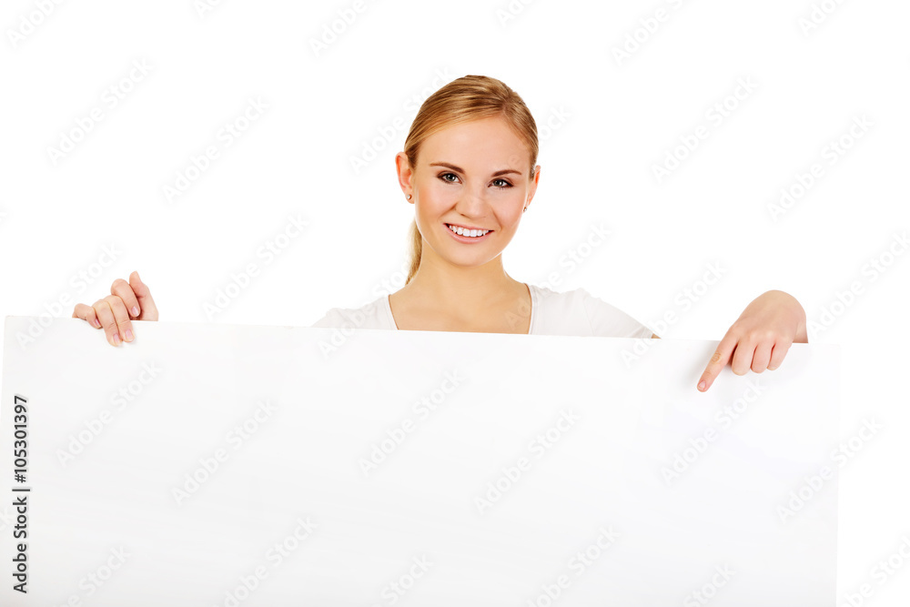 Smiling young woman pointing for empty banner Smiling young woman pointing for empty banner