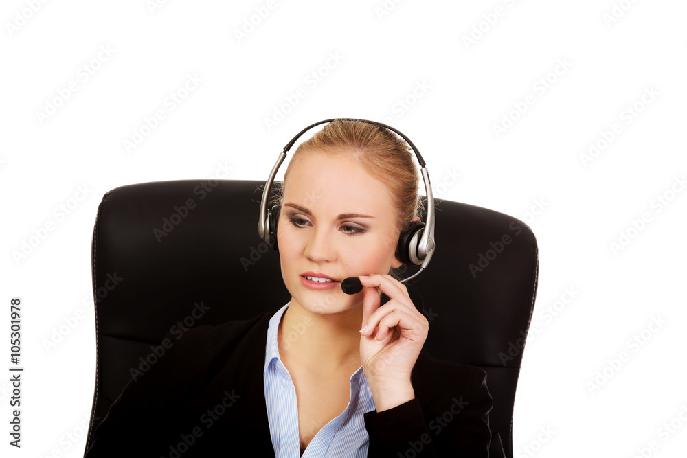 Young woman helpline operator is trying to hear something headphones Young woman helpline operator is trying to hear something headphones