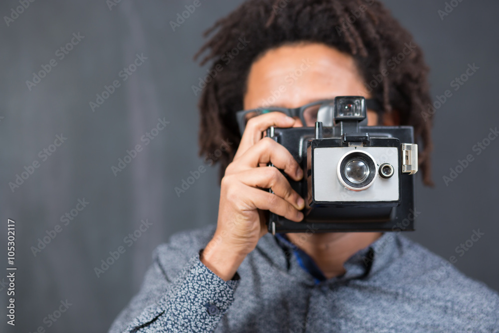 Happy hipster man smiling with toy camera on rustic backgorund Happy hipster man smiling with toy camera on rustic backgorund