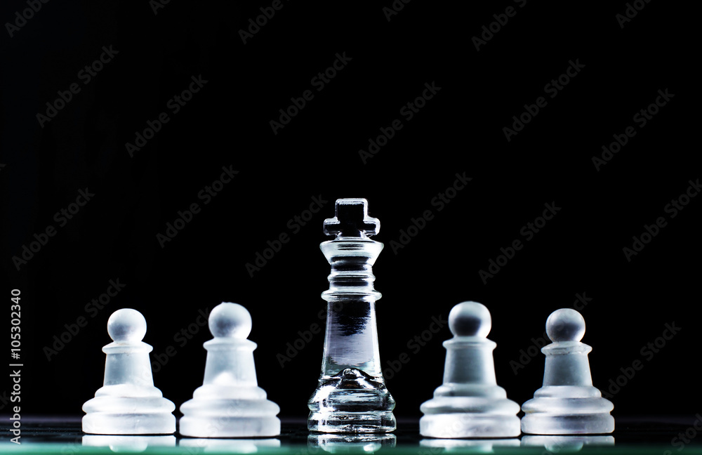 King and several pawns on chessboard in dark background. Hierarc King and several pawns on chessboard in dark background. Hierarc