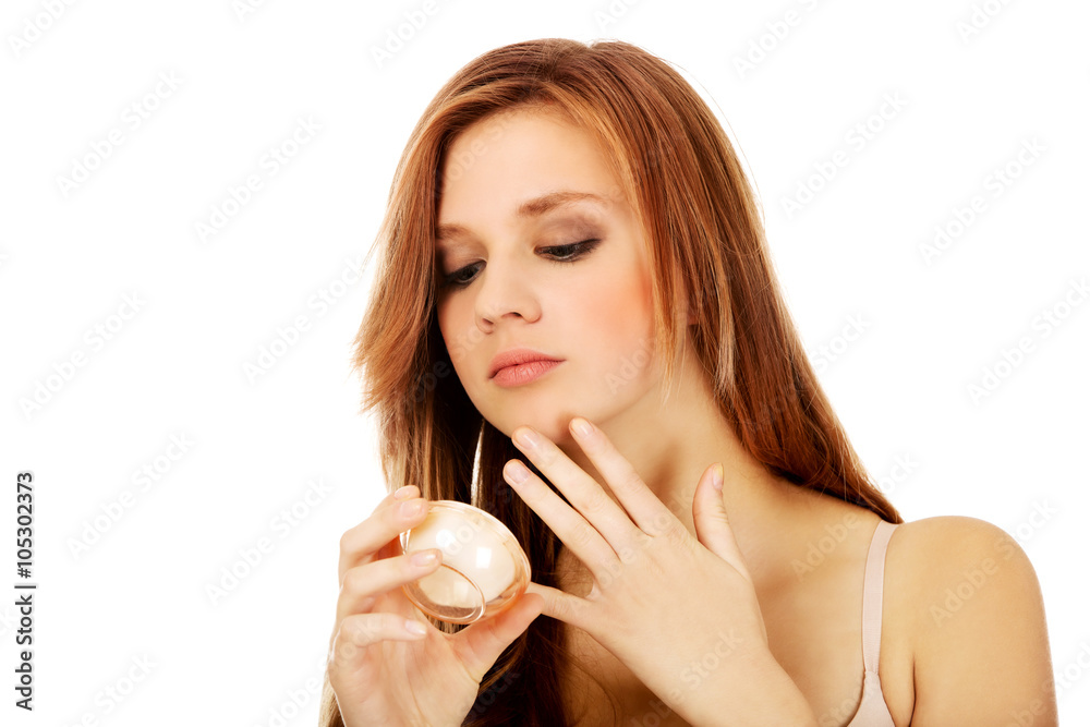 Happy young woman applying cream moisturizer Happy young woman applying cream moisturizer
