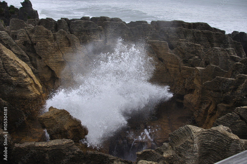 The main blowhole at Punakaiki on the West Coast of New Zealand, named Pluto, erupts with a gush of seawater at high tide.