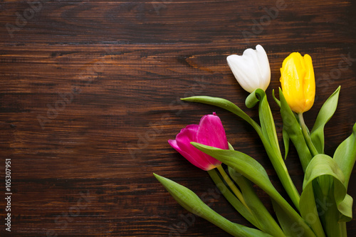 Fototapeta Naklejka Na Ścianę i Meble -  Tulips on a wooden background, view from above