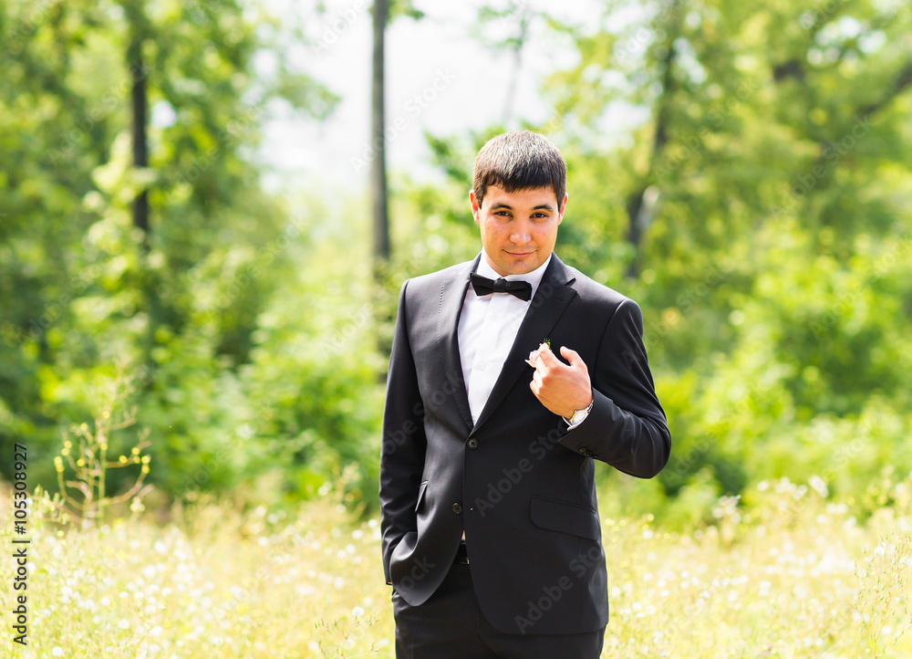 portrait of handsome stylish groom in black classic suit outdoors portrait of handsome stylish groom in black classic suit outdoors