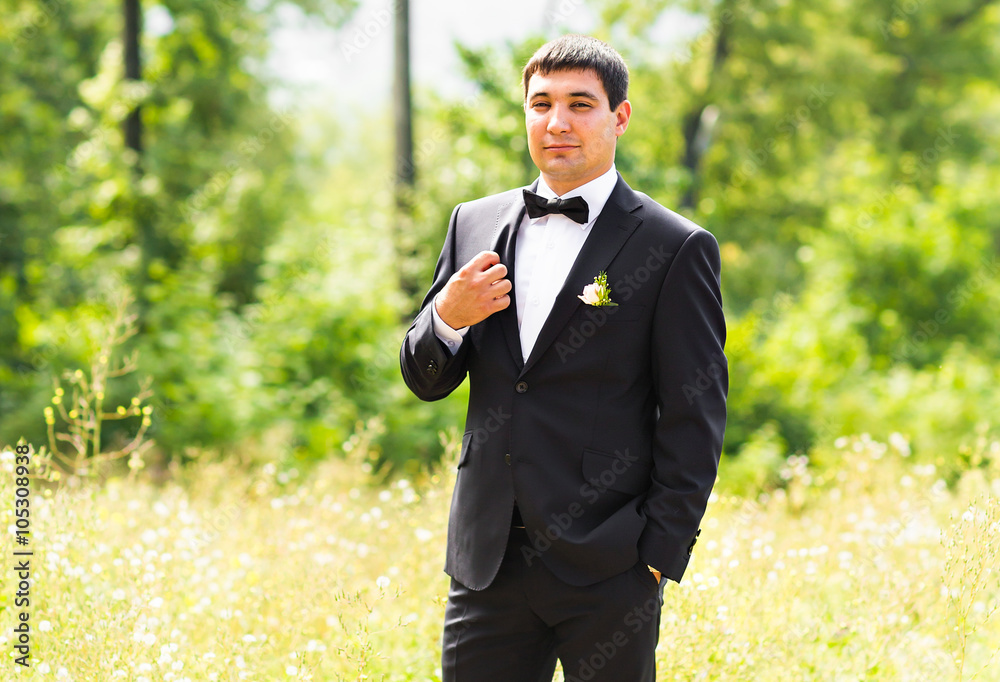 Close up portrait of handsome stylish groom in black classic suit outdoors Close up portrait of handsome stylish groom in black classic suit outdoors