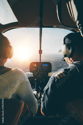 Pilots flying a helicopter on sunny day