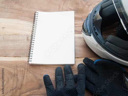 black gloves motorcycle and white helmet and white book on wood