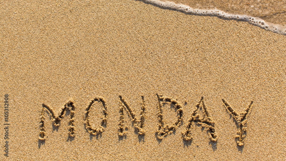 Monday - word drawn on the sand beach with the soft wave.