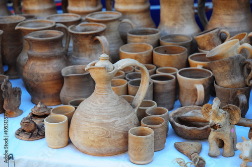 Close up on Traditional Ceramic Jugs on Decorative Towel. Showcase of Handmade Ukraine Ceramic Pottery in a Roadside Market with Ceramic Pots and Clay Plates Outdoors.
