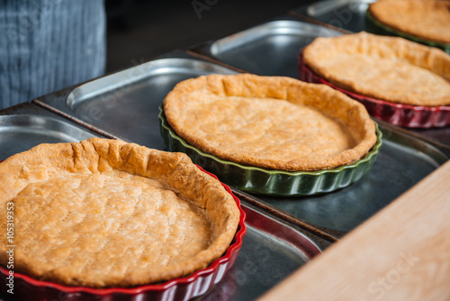 Cooked pie bases in baking pans on the kitchen