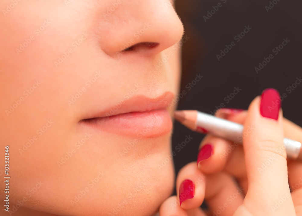 Applying lip products on a woman face.