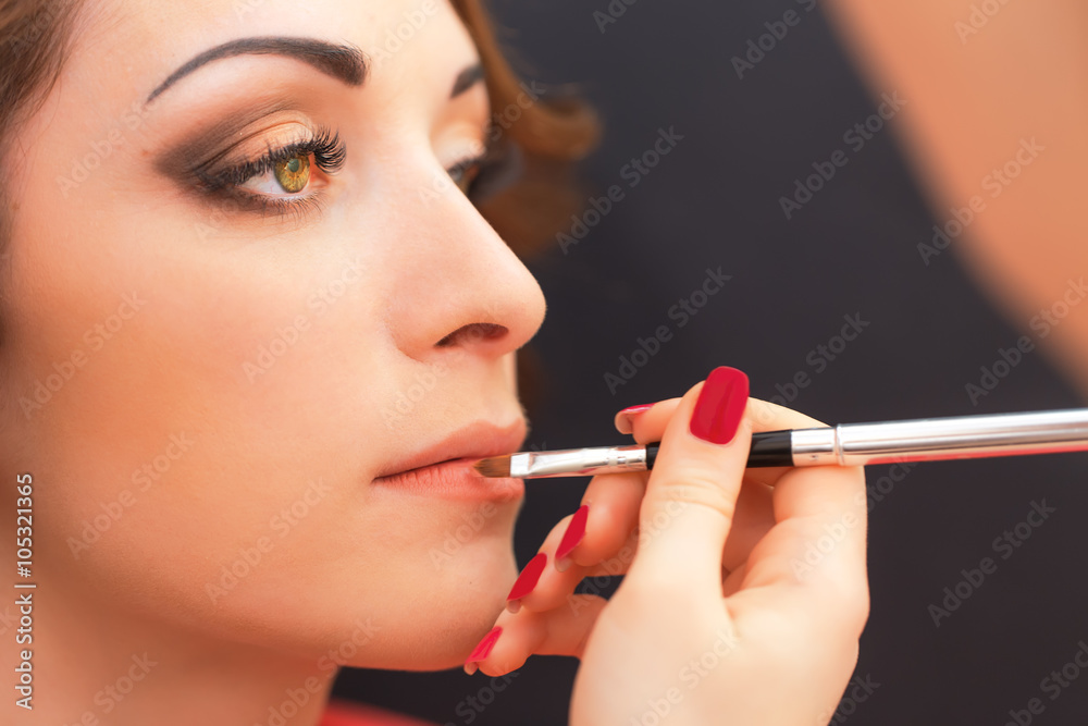 Applying lip products on a woman face. Applying lip products on a woman face.